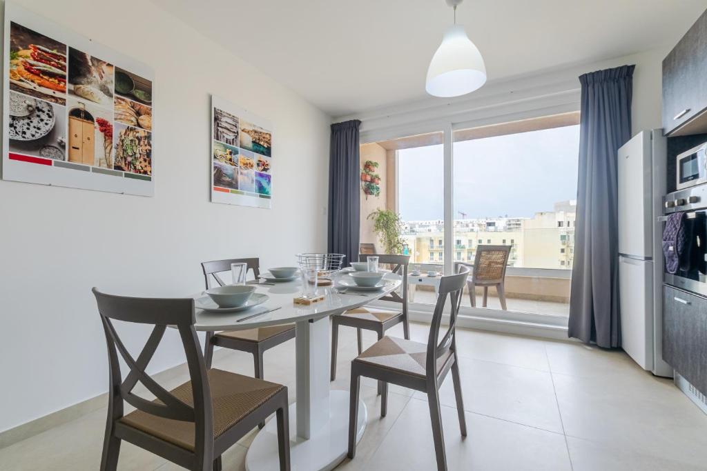 a kitchen and dining room with a table and chairs at Brand New Apartment 3 Bdr 2 Bth B10 in St. Paul's Bay