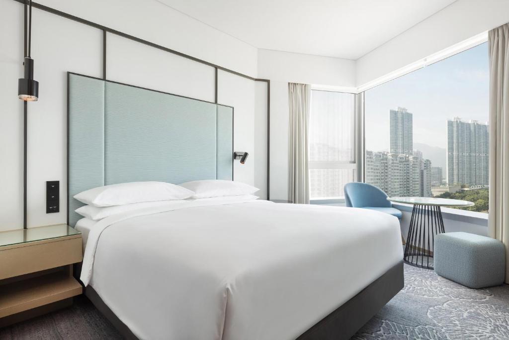 a bedroom with a large white bed and a large window at Four Points by Sheraton Hong Kong, Tung Chung in Hong Kong