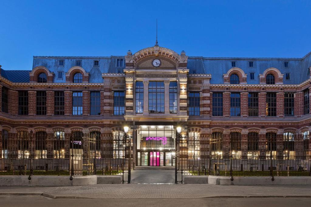 a large building with a clock on top of it at Moxy Lille City in Lille