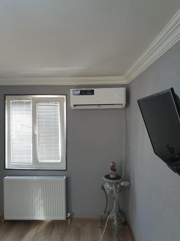 een kamer met verwarming, een tv en een raam bij Lamara apartament in Tbilisi City