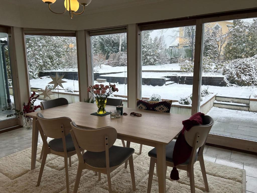 een eetkamer met een houten tafel en stoelen bij Villa Stockholm Täby in Stockholm