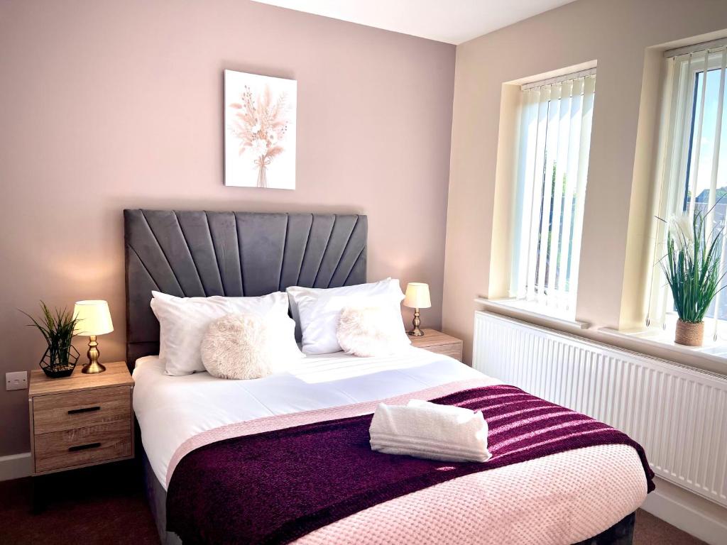 una camera da letto con un grande letto con una coperta viola di Comfy Casa - Syster Properties Serviced Accommodation Leicester Families, Work, Groups - Sleeps 13 a Leicester