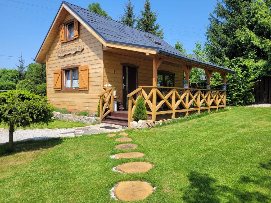 a log cabin with a porch and a lawn at Lawendowy domek in Mysłakowice