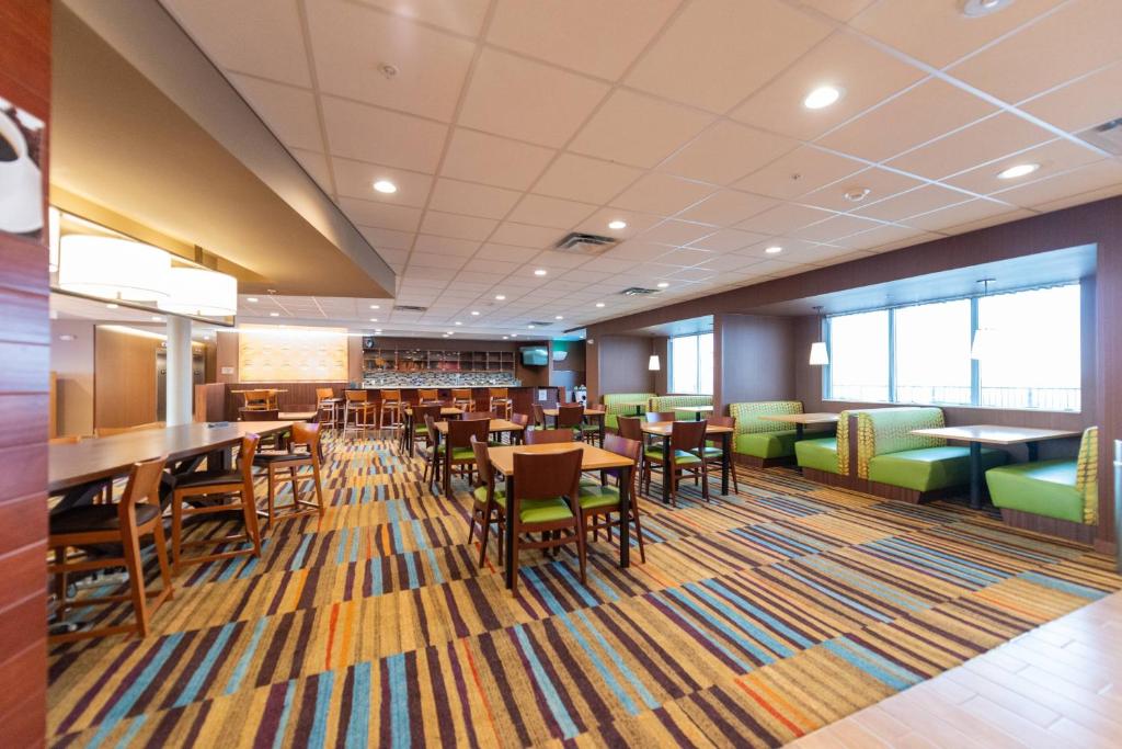 a dining room with tables and chairs in a building at Fairfield Inn & Suites by Marriott Sidney in Sidney