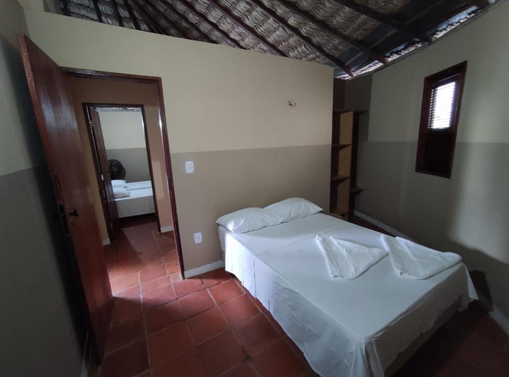 a bedroom with a bed and a bathroom with a mirror at Residência Europa in Luis Correia