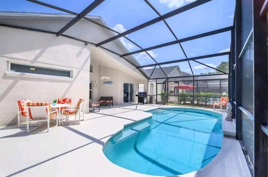 una piscina con techo de cristal en Fabulous, Quiet Family Resort Vacation Home, South Facing Pool, at Lake Berkley Resort, Near Disney, SeaWorld, en Kissimmee