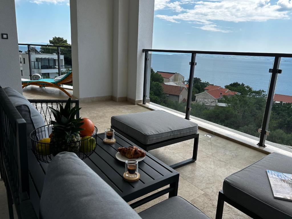 a living room with a couch and a table on a balcony at Ivana&Luka-superior wellnes in Brela