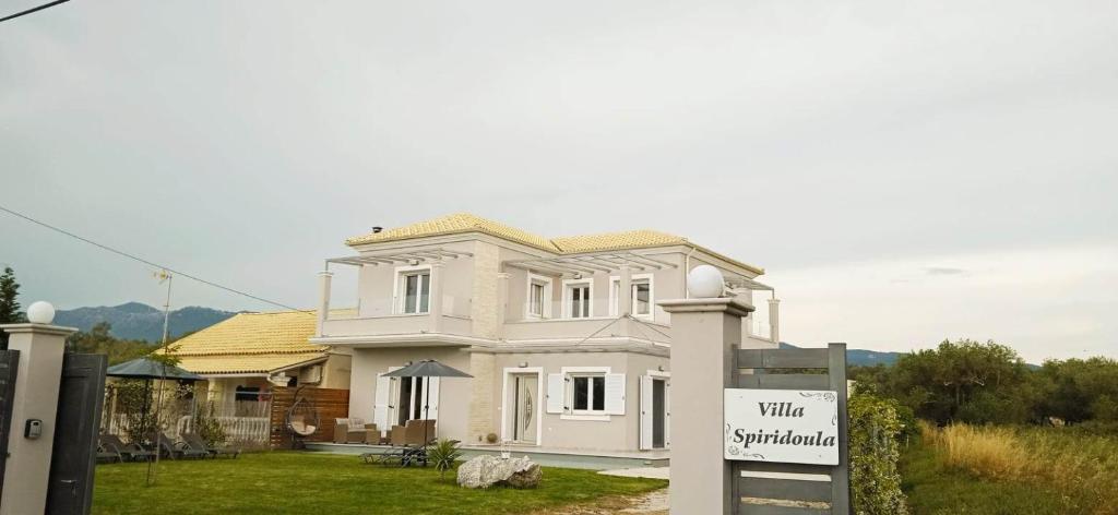 a white house with a sign in front of it at Spiridoula Luxury Villa in Roda