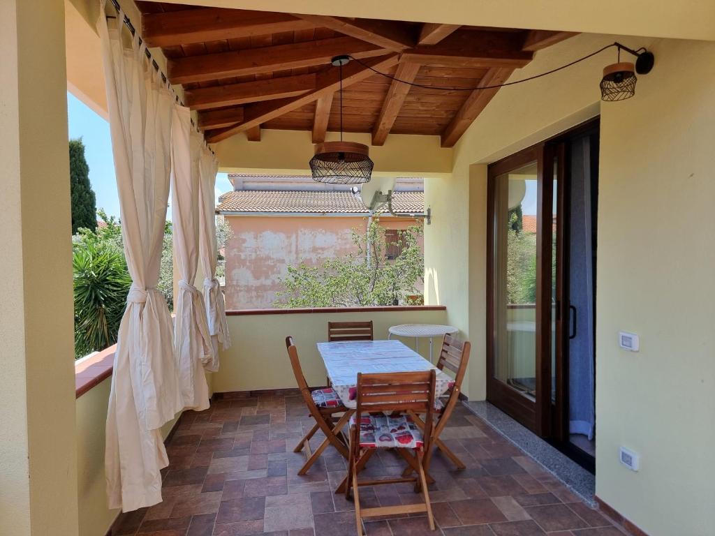 ein Esszimmer mit einem Tisch und Stühlen auf einer Terrasse in der Unterkunft Appartamento Via Toscana in Budoni