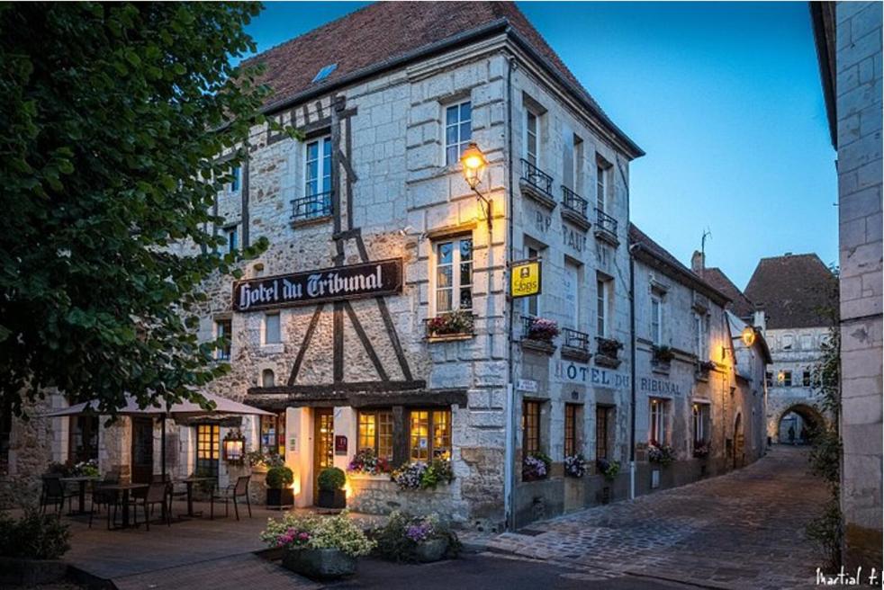 um edifício com um sinal na lateral em Logis - Hôtel & Restaurant du Tribunal em Mortagne-au-Perche