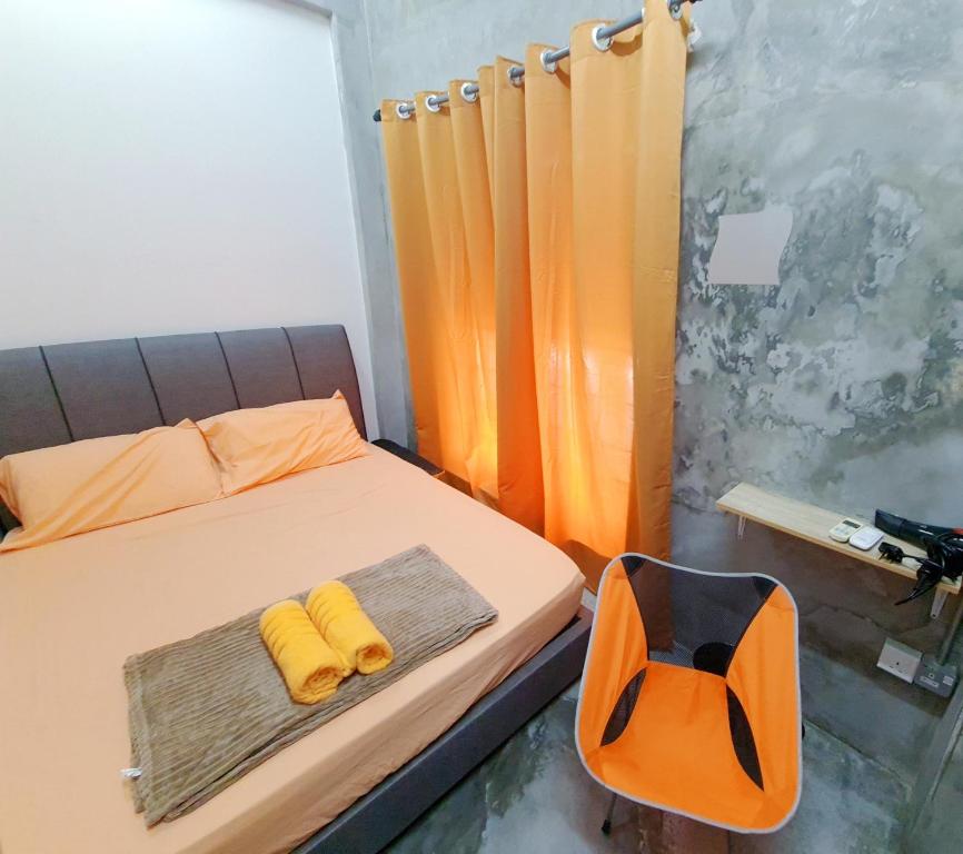 sypialnia z łóżkiem i 2 żółtymi ręcznikami w obiekcie Lot 85 Seremban Town New Cozy Homestay Lobak w mieście Seremban