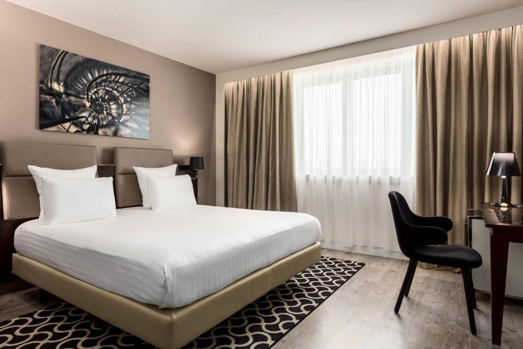 a bedroom with a bed and a desk and a chair at AC Hotel Paris Porte Maillot by Marriott in Paris