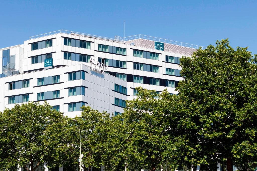 un grand bâtiment blanc avec des arbres devant lui dans l'établissement AC Hotel Paris Porte Maillot by Marriott, à Paris