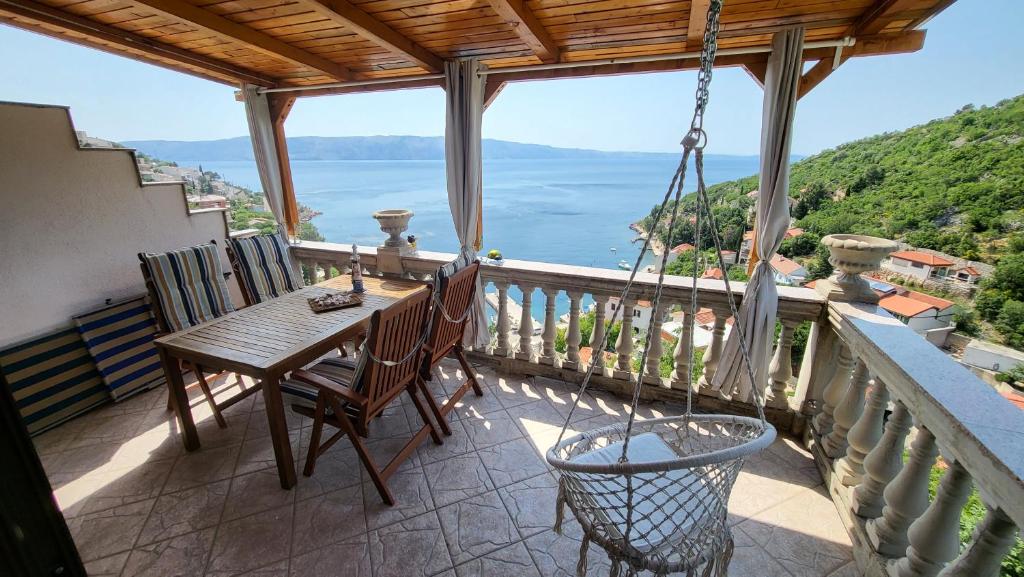 a porch with a wooden table and chairs on a balcony at Apartment Biondić in Starigrad