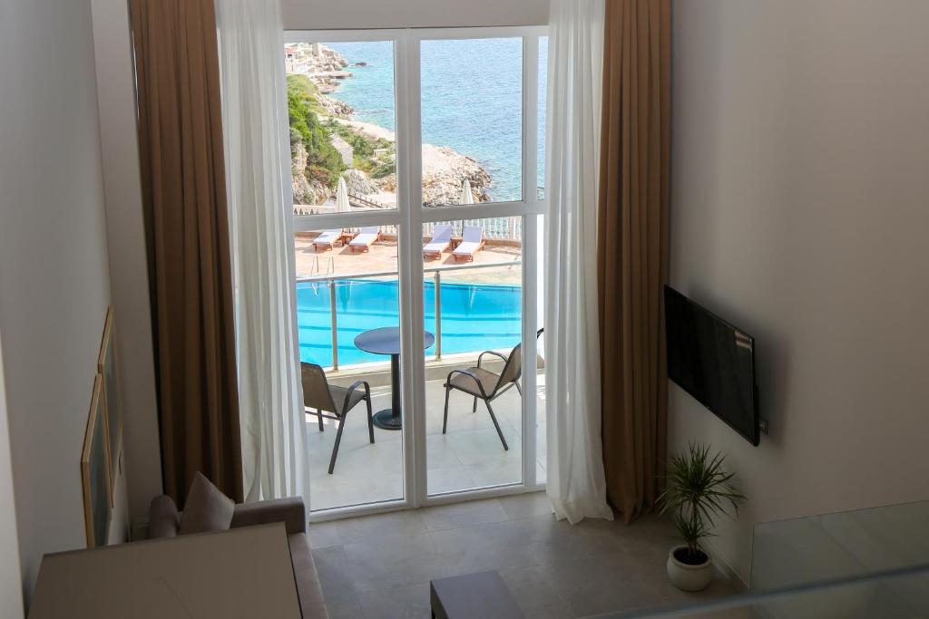 um quarto com uma grande janela com vista para o oceano em Toto Boutique Hotel & Apartments em Vlorë