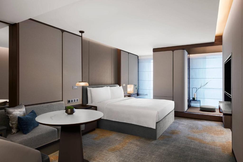 深圳的住宿－金茂深圳 JW 万豪酒店，一间卧室配有一张床、一张桌子和一张沙发