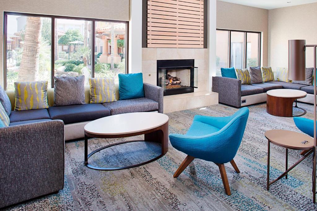 een woonkamer met banken en stoelen en een open haard bij Courtyard by Marriott Tucson Williams Centre in Tucson