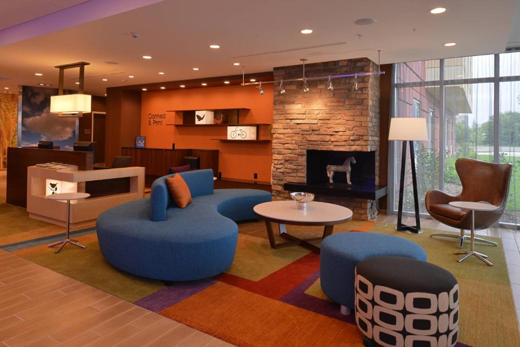 vestíbulo con sillas azules y chimenea en Fairfield Inn & Suites by Marriott Fremont, en Fremont