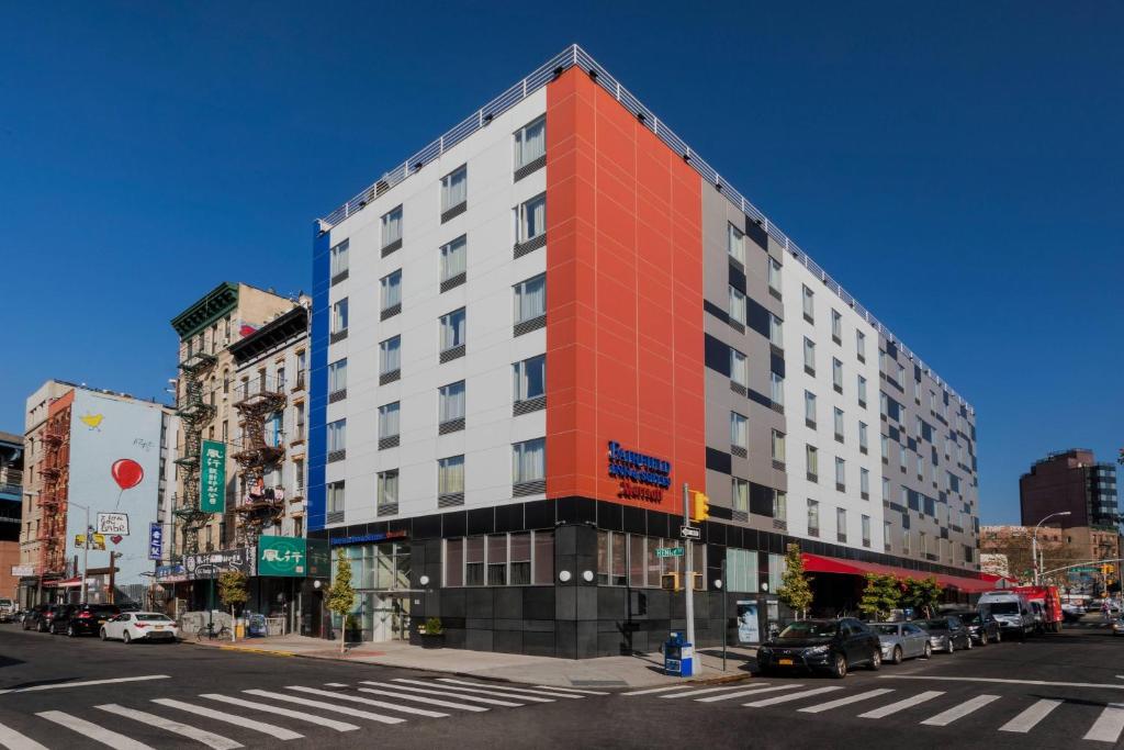 een oranje en wit gebouw in een stadsstraat bij Fairfield Inn & Suites New York Manhattan/Downtown East in New York