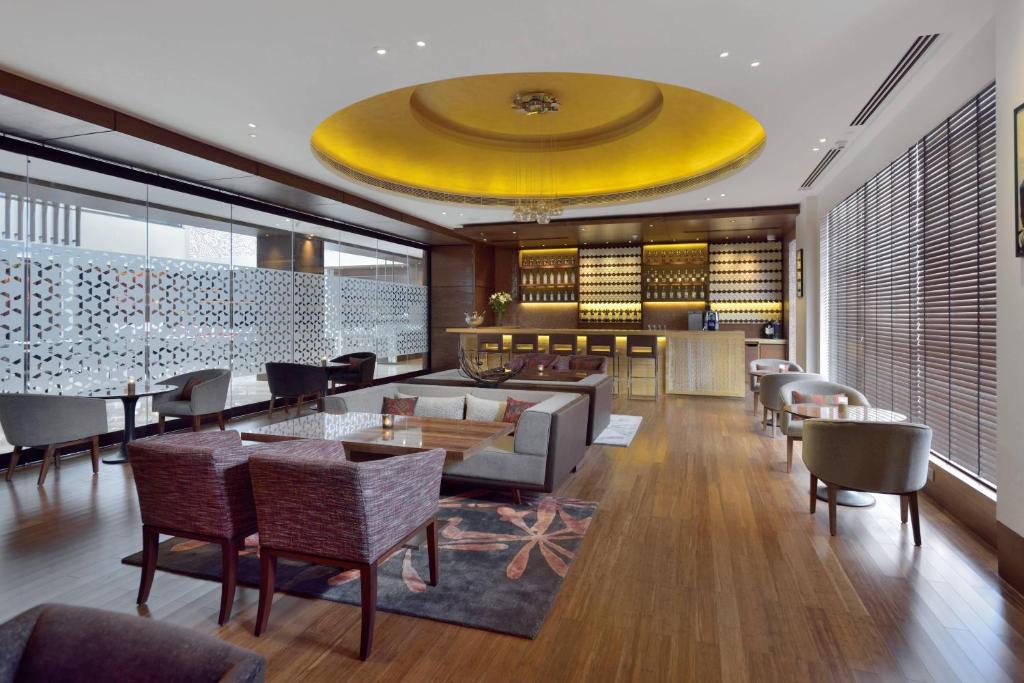 a hotel lobby with a large yellow ceiling at Courtyard by Marriott Raipur in Raipur