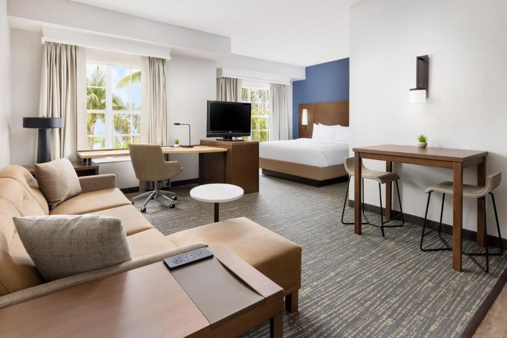ウェストパームビーチにあるResidence Inn West Palm Beachのソファとベッド付きのホテルルーム