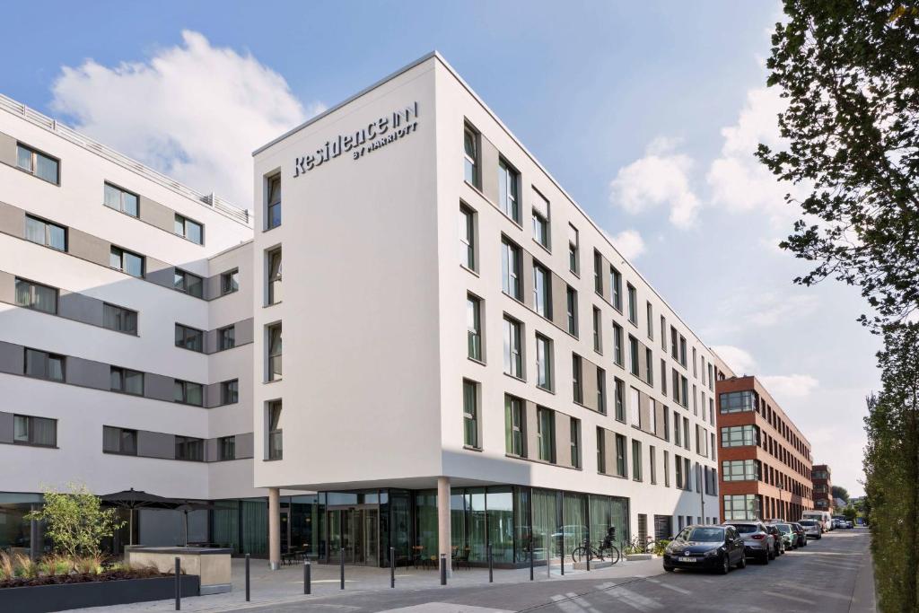 un bâtiment blanc avec un panneau sur son côté dans l'établissement Residence Inn by Marriott Hamburg Altona, à Hambourg