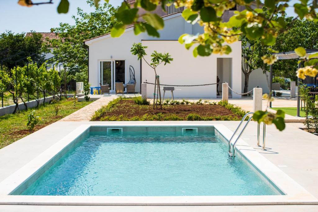 a swimming pool in the backyard of a house at Villa Skrila in Fažana