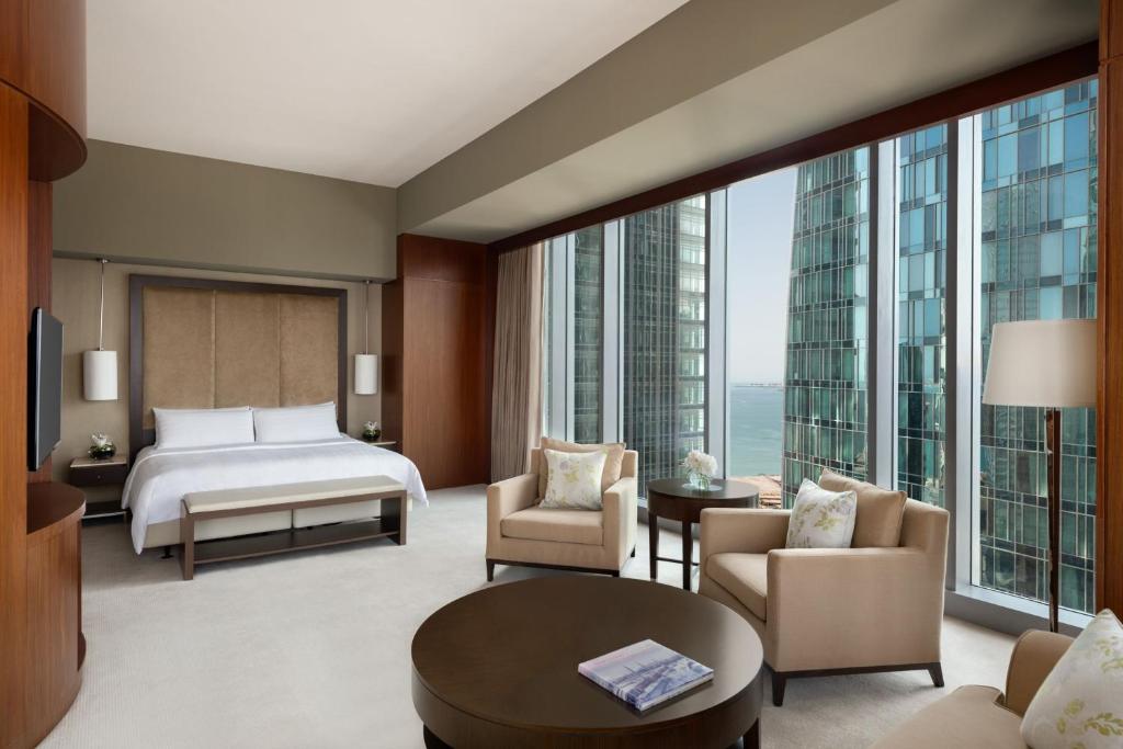 JW Marriott Marquis City Center Doha في الدوحة: غرفة فندقية بسرير ونافذة كبيرة