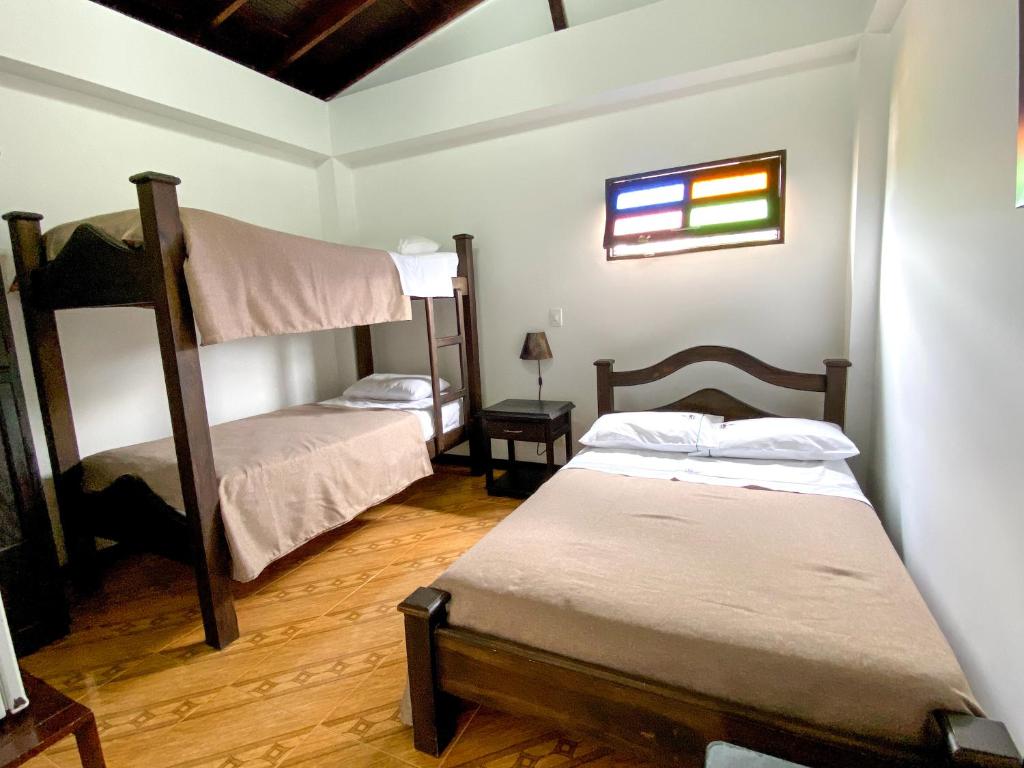 Hospedaje Casa Real في Salamina: غرفة نوم بسريرين بطابقين ونافذة