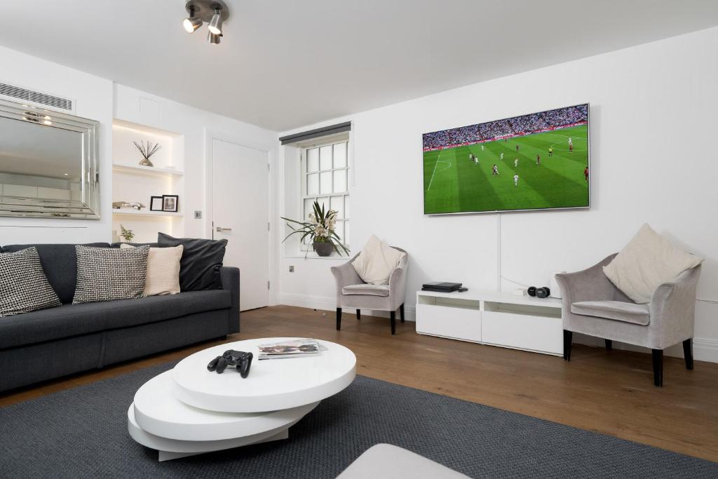 a living room with a couch and a soccer game at Aircon 2 Bedr, 3 Beds, 2 Bath Covent Garden, Subway in London