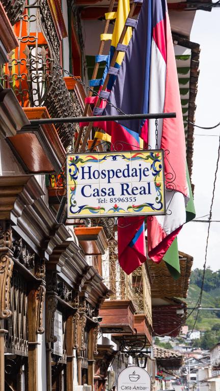 a sign for a caza real on a building with flags at Hospedaje Casa Real in Salamina