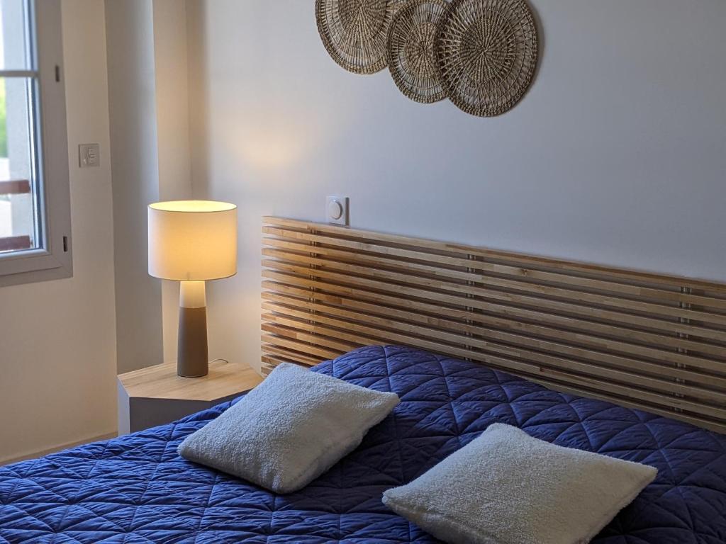 - une chambre avec un lit bleu et 2 oreillers dans l'établissement Chez Elsa, confortable apt neuf avec parking privé, à Saint-Valery-sur-Somme