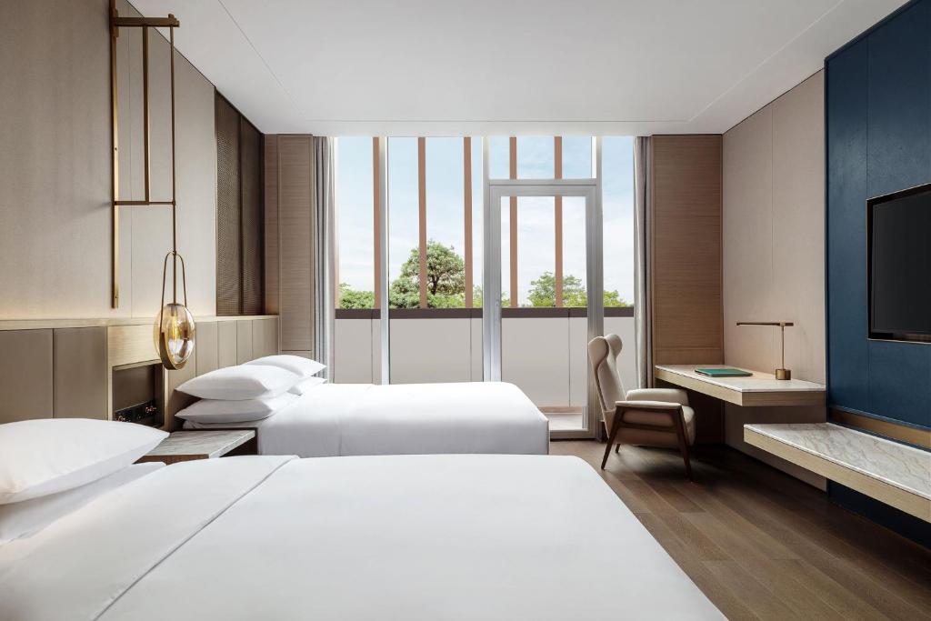Postel nebo postele na pokoji v ubytování Midea Shunde, a Tribute Portfolio Hotel