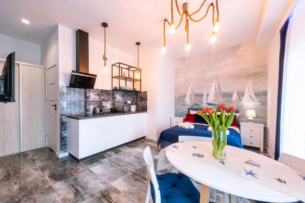 a bedroom with a bed and a table and chairs at Apartament Kapitański Centrum Łeba in Łeba