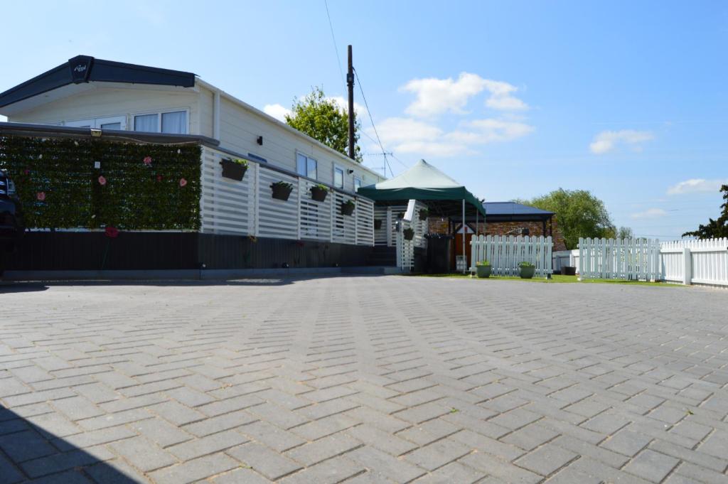 eine Terrasse mit einem weißen Gebäude und einem weißen Zaun in der Unterkunft River View Retreat in Offenham