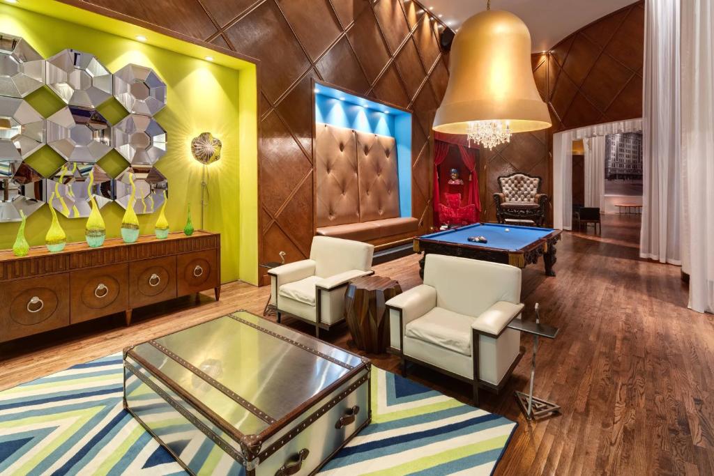 a living room with a ping pong table and chairs at The Saint Hotel, New Orleans, French Quarter, Autograph Collection in New Orleans
