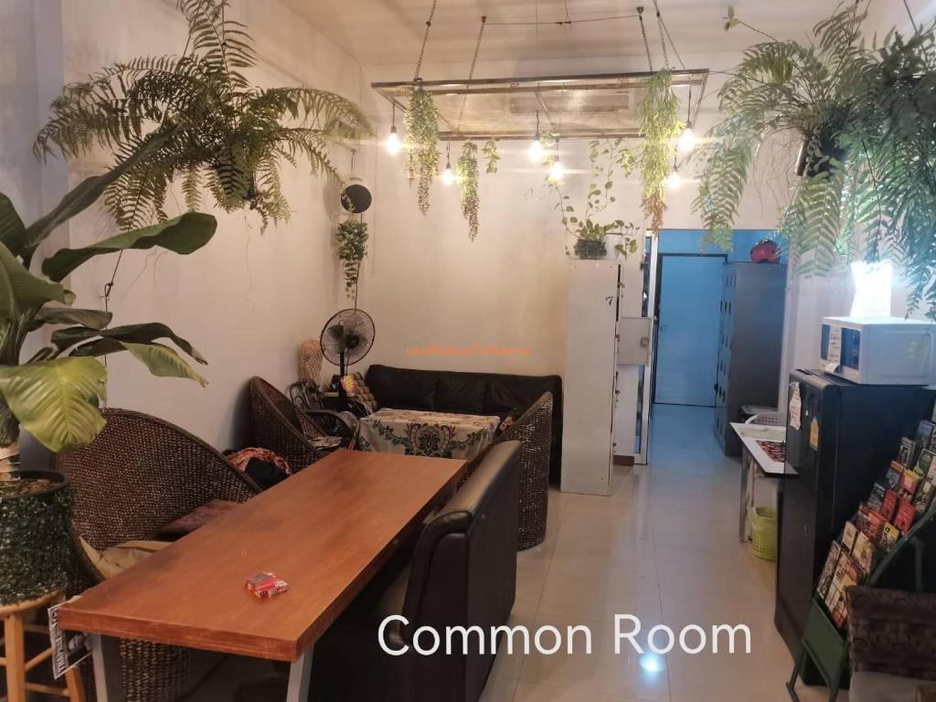 una habitación con una mesa y algunas plantas en Chiang Mai Happy House Hostel, en Chiang Mai