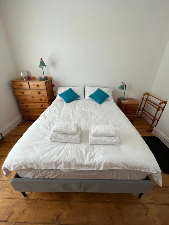 a bedroom with a white bed with blue pillows at Seaside Rooms Gorleston in Gorleston-on-Sea