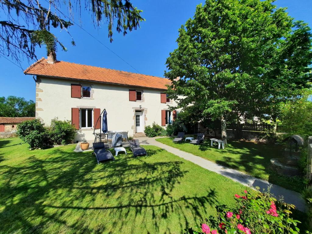 une maison avec une cour dotée de chaises et d'un arbre dans l'établissement Le Cottage de Paul et Angéline, à Boismé