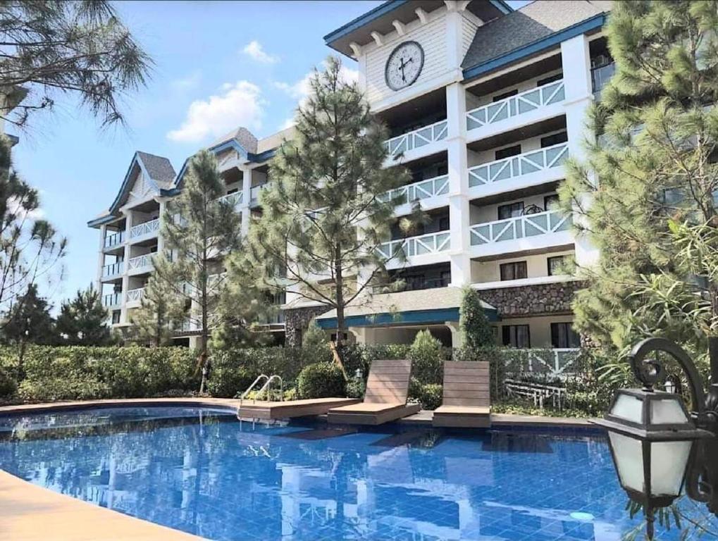 a hotel with a large building with a clock on it at Family Group Affordable Staycation in tagaytay in Tagaytay