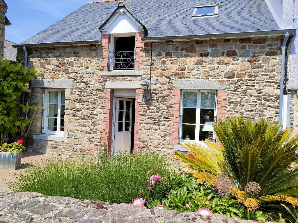 an old stone house with a garden in front of it at Maison de charme au Vivier-sur-Mer avec terrasse privée in Le Vivier-sur-Mer
