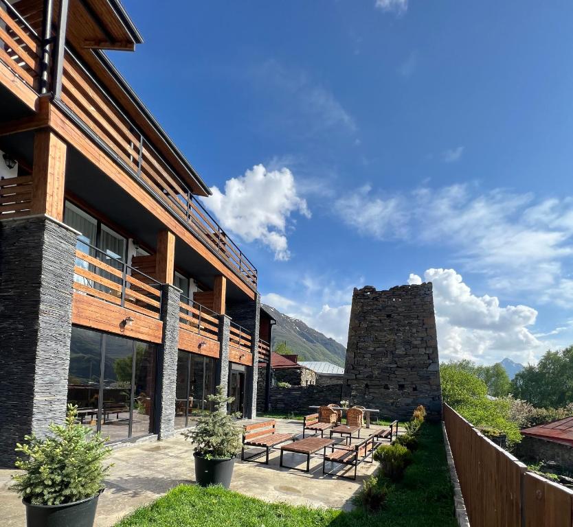 uma casa nas montanhas com um pátio em Capra Hotel Kazbegi em Kazbegi