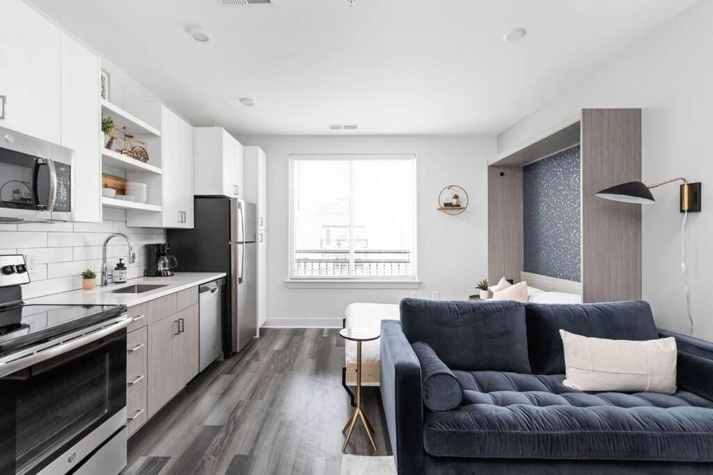 a living room with a blue couch in a kitchen at CozySuites Studio Apartment in Urban Indy in Indianapolis