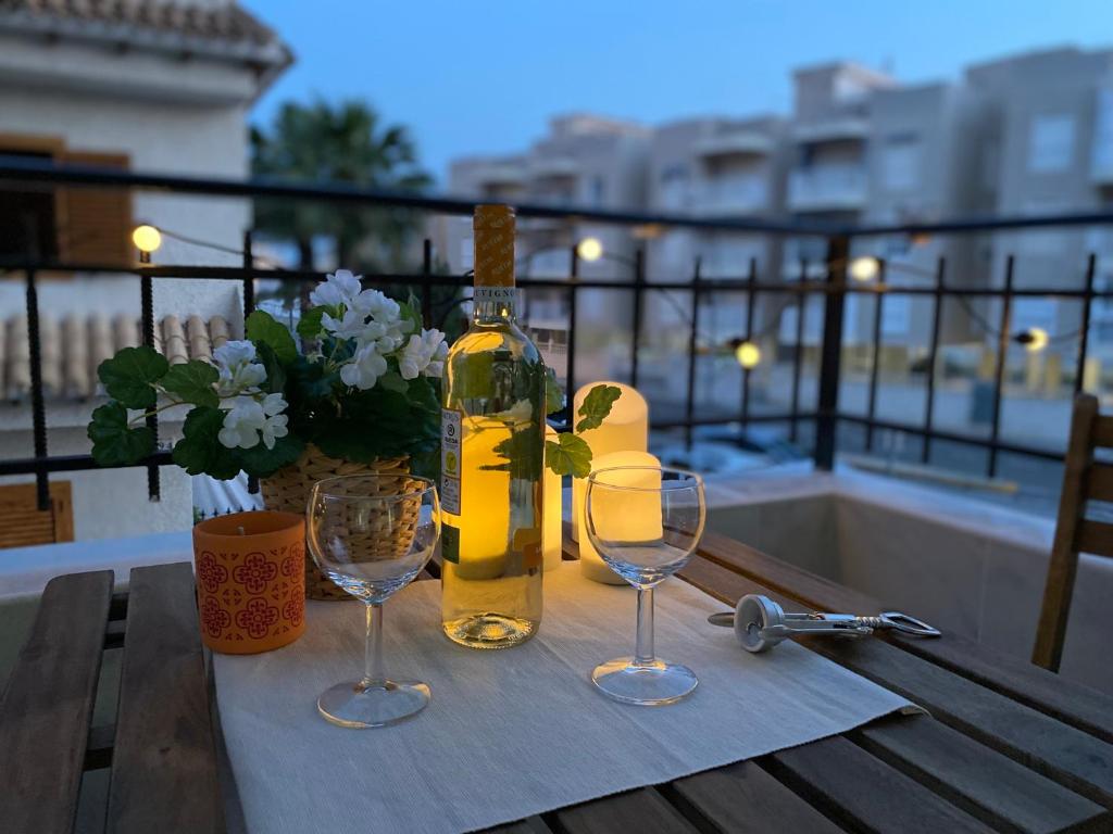 una botella de vino sentada en una mesa con dos copas de vino en LOVELY Sunset en Santa Pola
