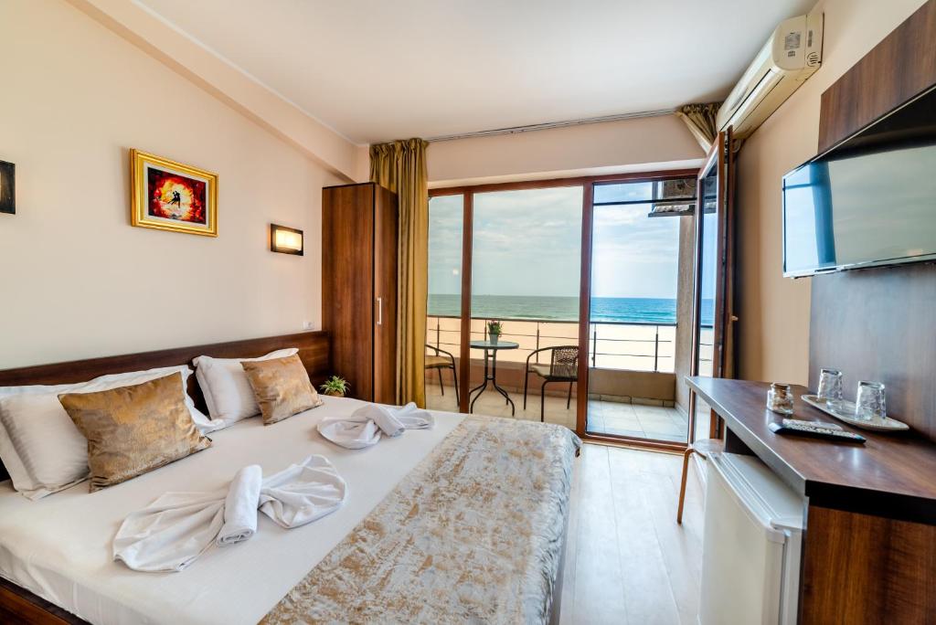 a hotel room with a bed with a view of the ocean at Hotel CASA ROYAL pe plaja Belona in Eforie Nord
