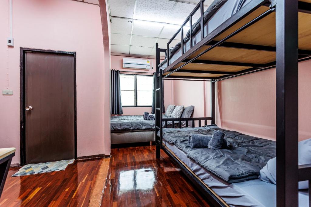 a room with two bunk beds and a door at Baan Mee Suk Ayutthaya in Phra Nakhon Si Ayutthaya