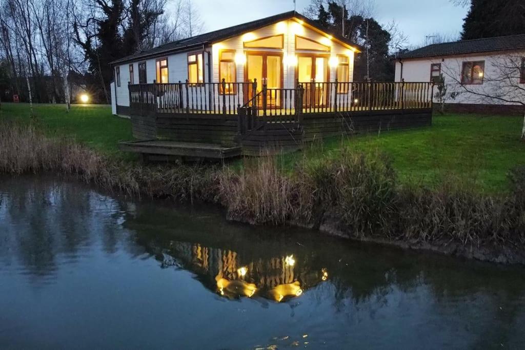 una casa con luces a orillas de un río en Lakeside View, en Wisbech
