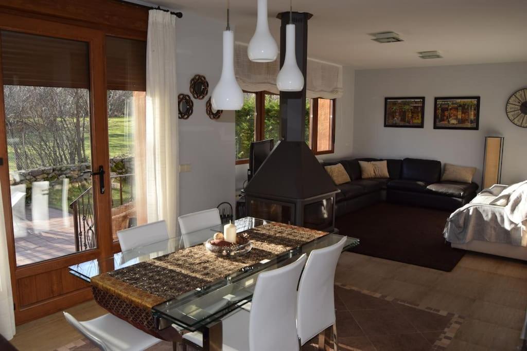 ein Wohnzimmer mit einem Tisch und ein Wohnzimmer mit einem Sofa in der Unterkunft Casa con jardín en Rascafría in Rascafría