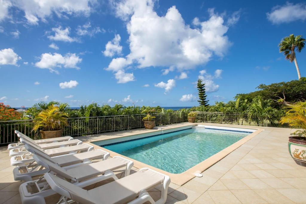 einen Pool mit Liegestühlen und Meerblick in der Unterkunft Villa Madras in Les Terres Basses