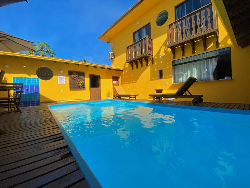 a swimming pool in front of a yellow house at Pousada Maravilha de Paraty in Paraty